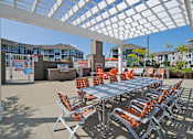 Thumbnail 18 of 21 - an outdoor patio with tables and chairs under a white canopy