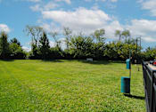Thumbnail 20 of 21 - a large field of grass next to a fence and trees