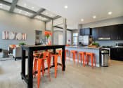 Thumbnail 13 of 21 - a large kitchen and dining room with orange stools