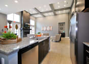 Thumbnail 14 of 21 - a kitchen with a counter top and a refrigerator