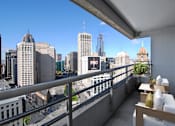 Thumbnail 13 of 41 - A balcony with a table and chairs overlooking a cityscape.