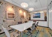 Thumbnail 35 of 41 - A conference room with a white table and chairs.