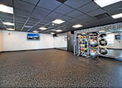 Thumbnail 23 of 41 - A gym with a variety of equipment including kettlebells and dumbbells.