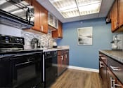 Thumbnail 17 of 44 - A kitchen with black appliances and wooden cabinets.