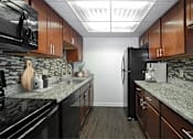Thumbnail 15 of 44 - A kitchen with black appliances and wooden cabinets.