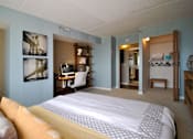 Thumbnail 6 of 41 - a bedroom with a bed and a desk in a hotel room