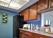 Thumbnail 5 of 41 - a kitchen with wooden cabinets and a black refrigerator