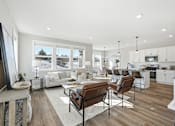 Thumbnail 9 of 44 - A modern living room with a brown leather chair in the foreground.