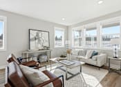 Thumbnail 3 of 44 - A living room with a brown leather chair and a glass coffee table.