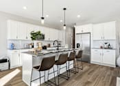 Thumbnail 10 of 44 - A modern kitchen with white cabinets and a central island.