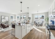 Thumbnail 7 of 44 - A modern kitchen with a large island and a dining area.