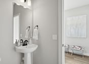Thumbnail 37 of 44 - A white bathroom with a sink, mirror, and toilet.