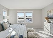 Thumbnail 23 of 44 - A bedroom with a large bed and a window overlooking a snowy landscape.