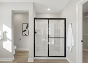 Thumbnail 30 of 44 - A white bathroom with a glass door.