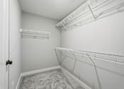 Thumbnail 36 of 44 - A white closet with a carpeted floor and a door on the left.