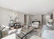 Thumbnail 16 of 44 - A modern living room with a white sofa, a grey couch, a wooden coffee table, and a large abstract painting on the wall.