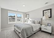 Thumbnail 25 of 44 - A bedroom with a large bed and a window showing a snowy landscape outside.