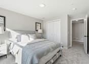 Thumbnail 4 of 44 - A bedroom with a bed, nightstand, and a painting on the wall.