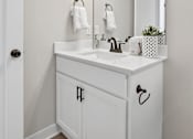 Thumbnail 33 of 44 - A white bathroom with a sink and mirror.