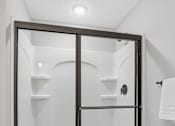 Thumbnail 35 of 44 - A white toilet is in a bathroom with a walk-in shower.