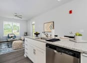 Thumbnail 3 of 26 - A modern kitchen with a stainless steel dishwasher and white cabinets.