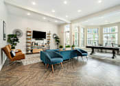Thumbnail 21 of 26 - a living room with a blue couch and chairs and a pool table