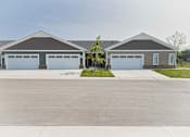 Thumbnail 17 of 18 - A large, two-story building with a garage door on each side.