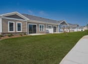 Thumbnail 11 of 28 - a row of homes with a lawn and sidewalk in front of them