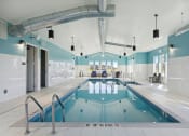 Thumbnail 14 of 28 - a swimming pool in a room with blue and white walls and a ladder over it