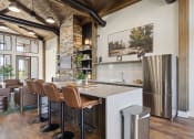 Thumbnail 17 of 28 - a kitchen with a bar and chairs and a refrigerator