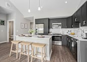Thumbnail 3 of 42 - A modern kitchen with a white island and wooden stools.