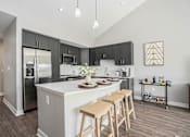 Thumbnail 2 of 42 - A kitchen with a white island and wooden bar stools.