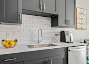 Thumbnail 6 of 42 - A modern kitchen with a bowl of lemons on the counter.