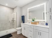 Thumbnail 12 of 42 - A white bathroom with a toilet, sink, and mirror.