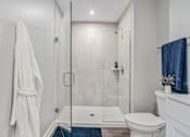 Thumbnail 13 of 42 - A white bathroom with a towel hanging on the wall.