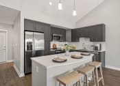 Thumbnail 3 of 31 - a kitchen with a large island and a stainless steel refrigerator