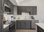 Thumbnail 4 of 31 - a kitchen with black cabinets and white counters and a sink