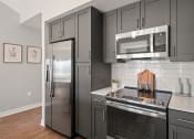 Thumbnail 5 of 31 - a kitchen with stainless steel appliances and black cabinets