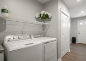 Thumbnail 14 of 31 - a washer and dryer in a laundry room with a white door