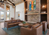 Thumbnail 19 of 31 - a living room with leather furniture and a stone fireplace