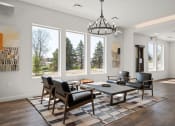 Thumbnail 22 of 31 - a living room with a table and chairs and large windows