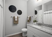 Thumbnail 11 of 53 - A bathroom with a toilet, sink, mirror, and towel rack.