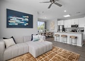 Thumbnail 1 of 53 - A modern living room with a grey sofa and a painting on the wall.