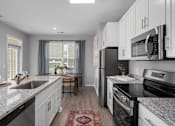 Thumbnail 4 of 53 - A kitchen with black appliances and white cabinets.