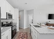 Thumbnail 5 of 53 - A kitchen with white cabinets and a black fridge.