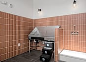 Thumbnail 20 of 53 - A bathroom with a brown tiled wall and a white bathtub.