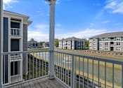 Thumbnail 13 of 53 - A balcony with a railing overlooking a body of water with buildings in the background.