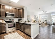 Thumbnail 35 of 53 - A modern kitchen with dark wood cabinets and stainless steel appliances.