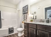 Thumbnail 40 of 53 - A bathroom with a white toilet and a white bathtub.