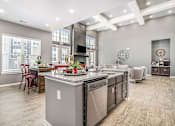 Thumbnail 43 of 53 - A kitchen with a large island and stainless steel appliances.